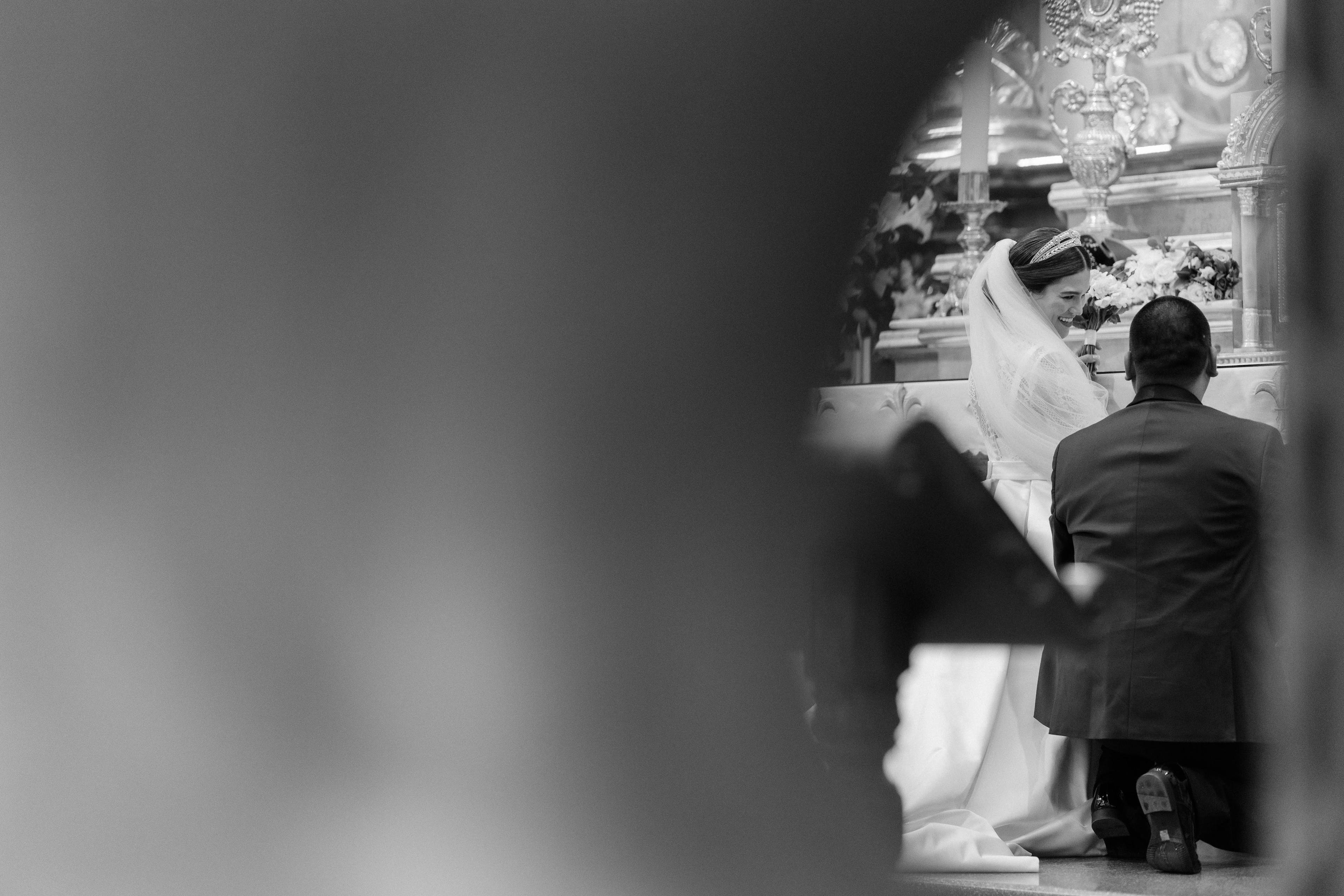 La ceremonia vista entre las columnas del altar — Rosalina sonríe mientras intercambian votos